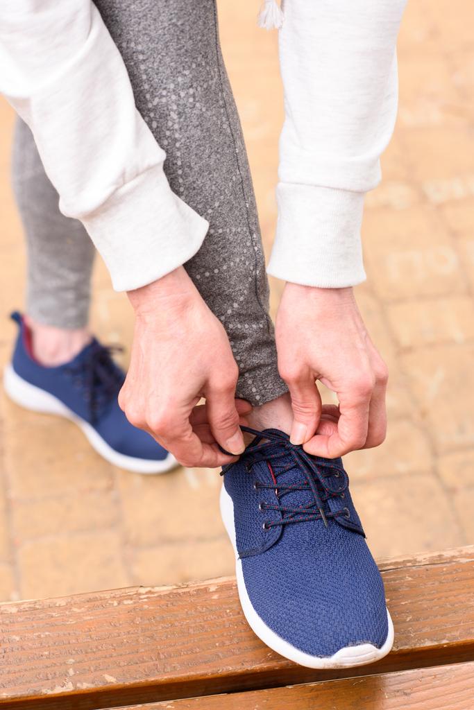 rajattu näkymä urheilija sitominen kengännauhat lenkkarit
 - Valokuva, kuva