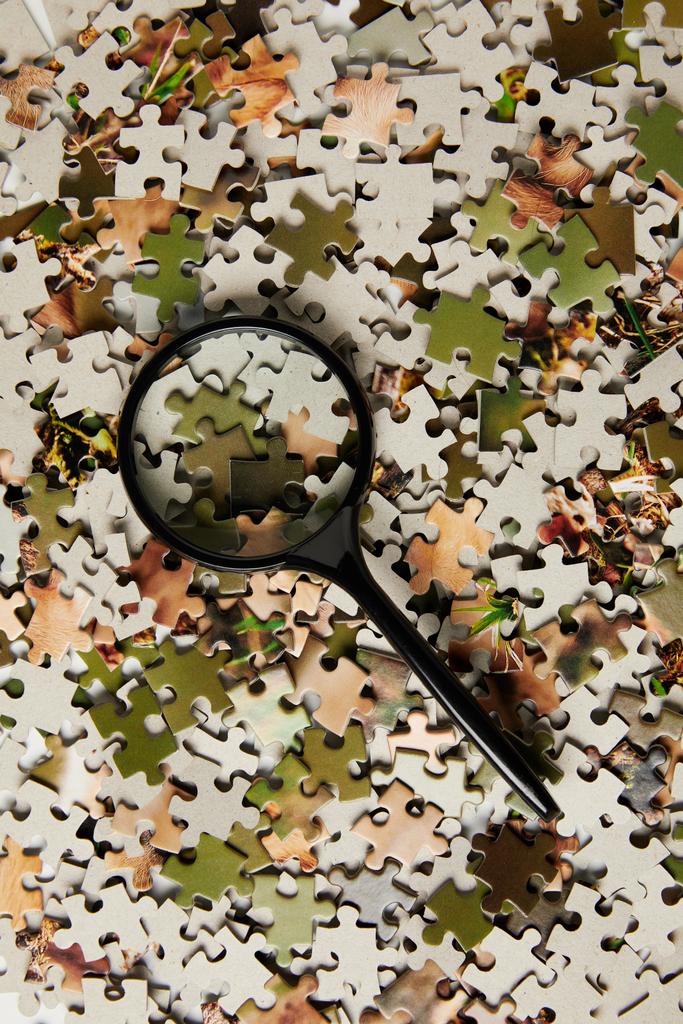 vista superior de lupa e peças de quebra-cabeça de quebra-cabeça em cinza
  - Foto, Imagem
