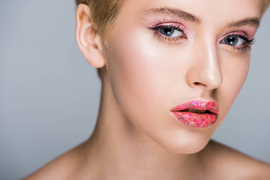 beautiful woman with stylish glittering makeup looking at camera isolated on grey - Photo, Image