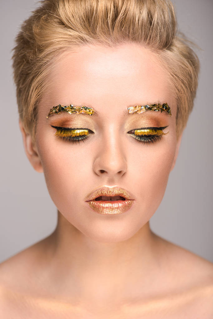 Altın glitter yüz ve kısa saç üzerinde izole gri seyir çekici kadın - Fotoğraf, Görsel