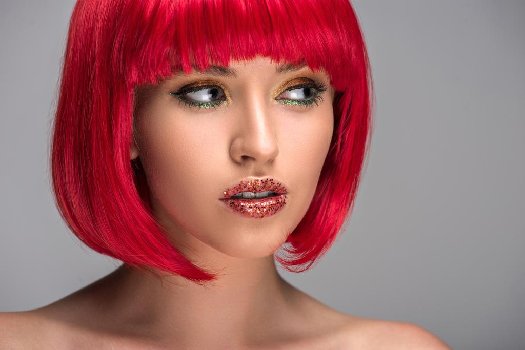 портрет привлекательной женщины с рыжими волосами и блестками на лице, смотрящей в сторону, изолированной от серого
 - Фото, изображение