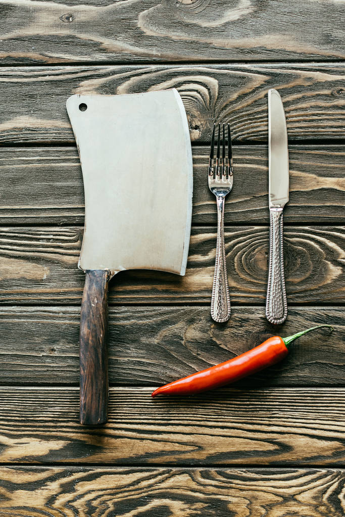 Platería y cuchilla con chile rojo sobre mesa de madera
 - Foto, imagen