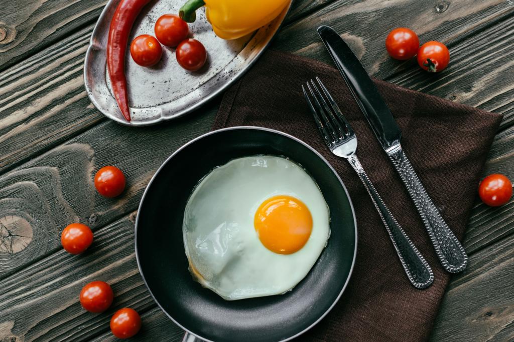 Концепція чистого харчування зі смаженим яйцем та сирими овочами на дерев'яному столі
 - Фото, зображення
