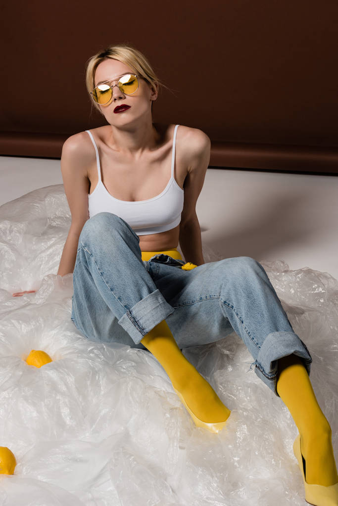 bela jovem mulher loira elegante em óculos de sol amarelos posando em estúdio
 - Foto, Imagem