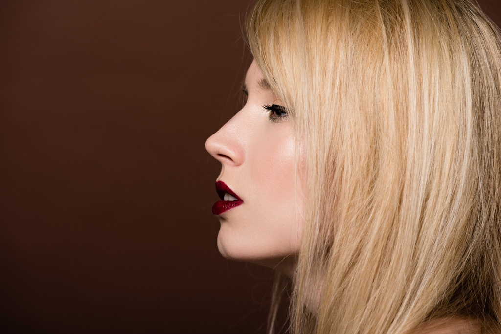 boční pohled krásná mladá blond žena při pohledu od izolovaných na hnědé  - Fotografie, Obrázek