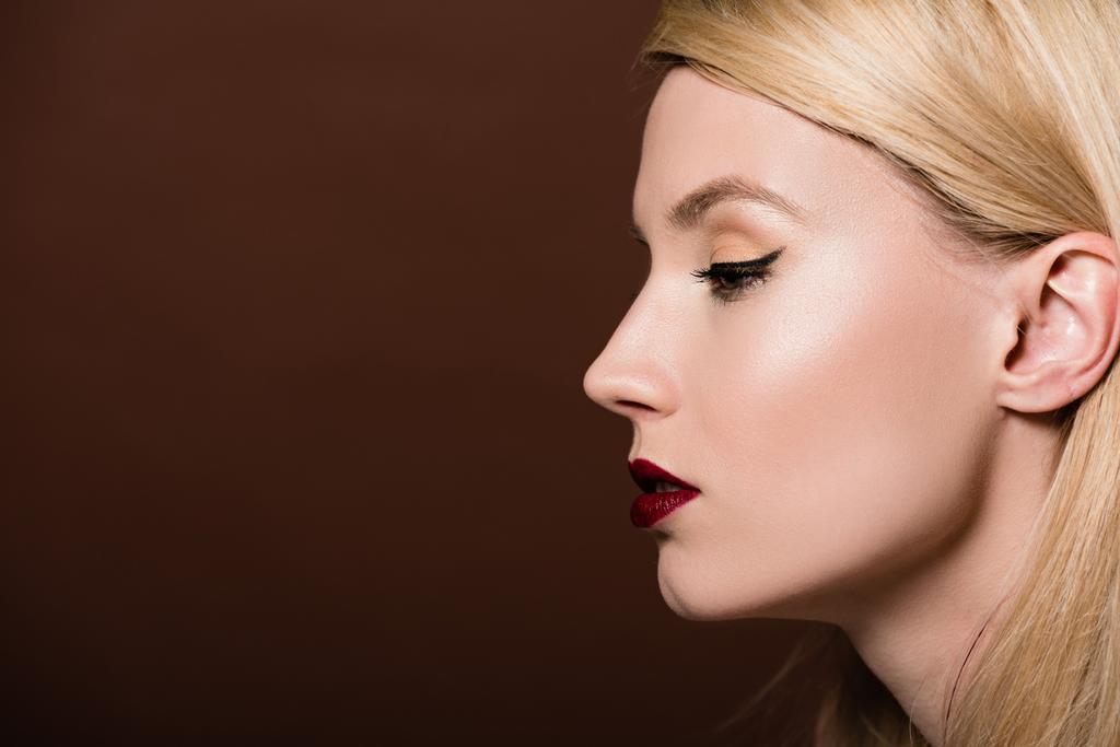 profile portrait of beautiful young blonde woman looking away isolated on brown  - Photo, Image