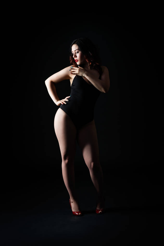 Hermosa mujer sexy en traje de cuerpo posando sobre fondo de estudio negro, cuerpo femenino perfecto, toma de estudio de baja clave
 - Foto, imagen