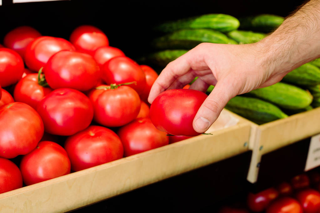 Mans hand choosing tomatoes in grocery - Photo, Image