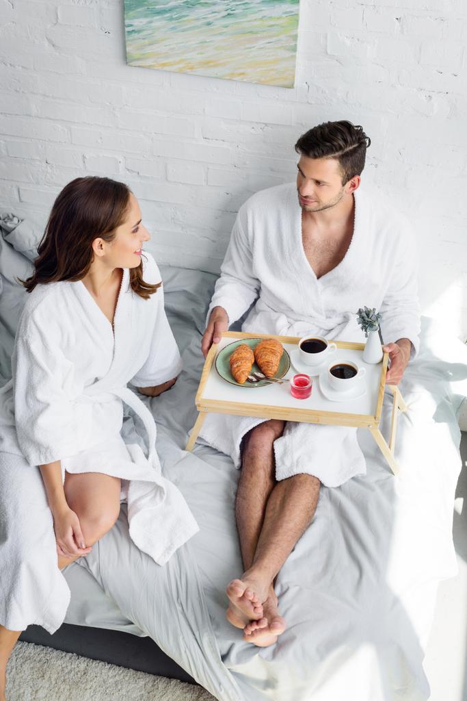 giovane coppia che fa colazione sul vassoio a letto
 - Foto, immagini