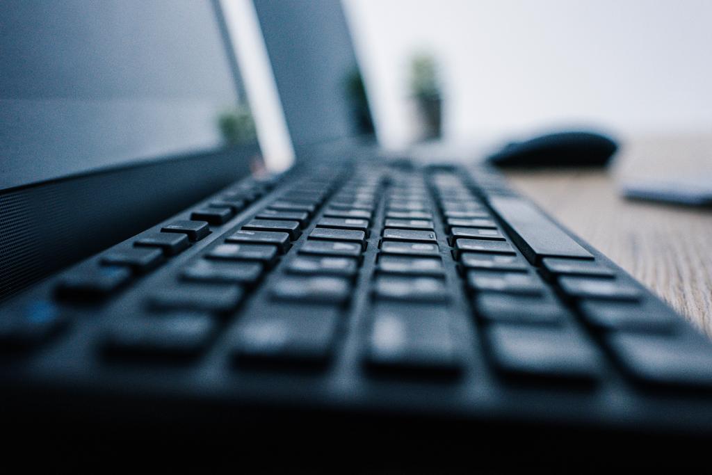 vue rapprochée du clavier d'ordinateur à la table avec souris d'ordinateur et ordinateur portable sur fond flou
  - Photo, image