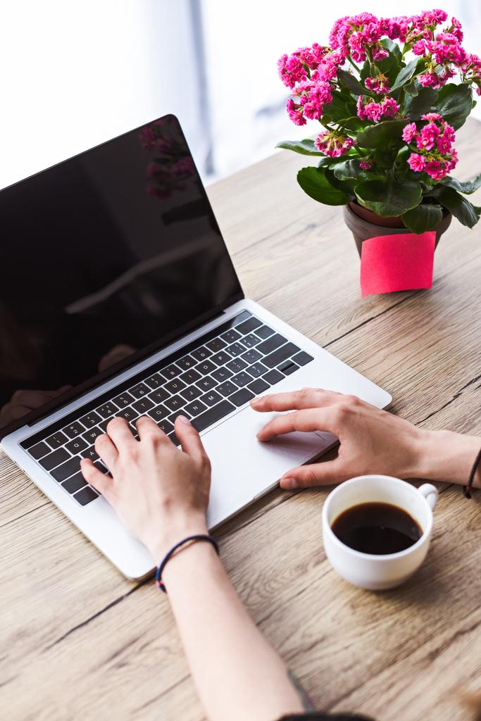 kahve fincanı ve çiçeklerle masada boş ekran ile Laptop yazarak kadın görüntüsünü kırpılmış  - Fotoğraf, Görsel