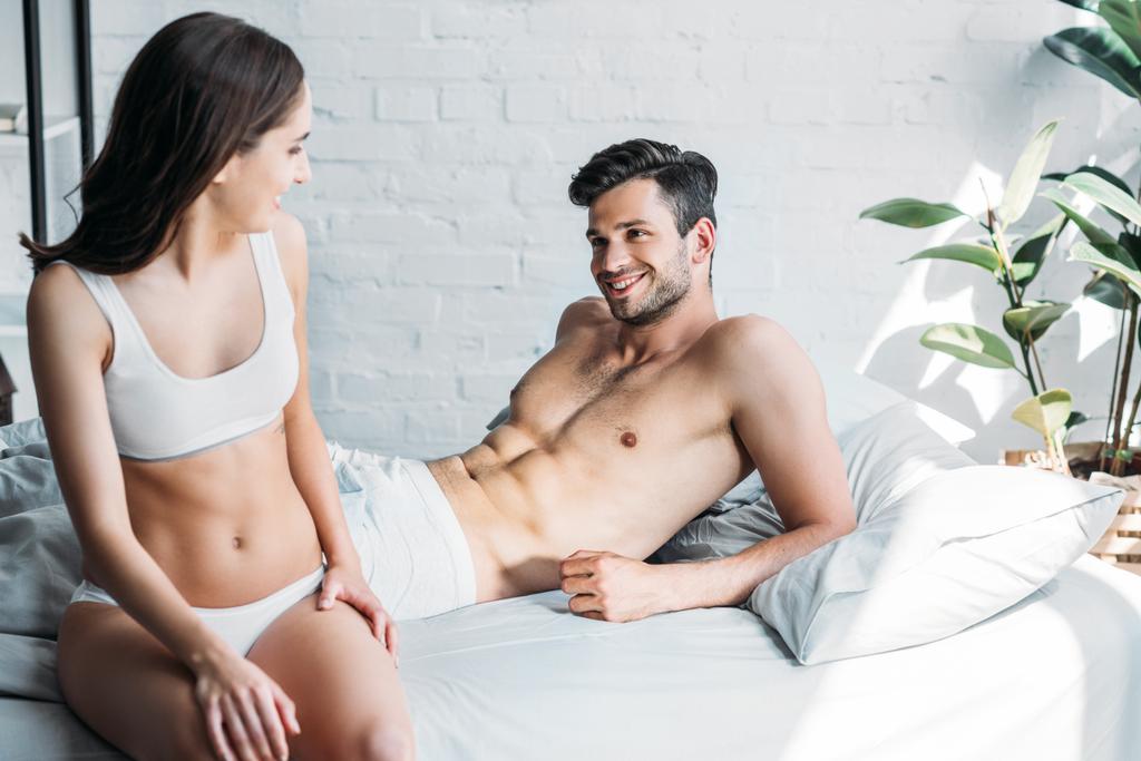 affettuosa coppia sorridente che si guarda a letto a casa
 - Foto, immagini
