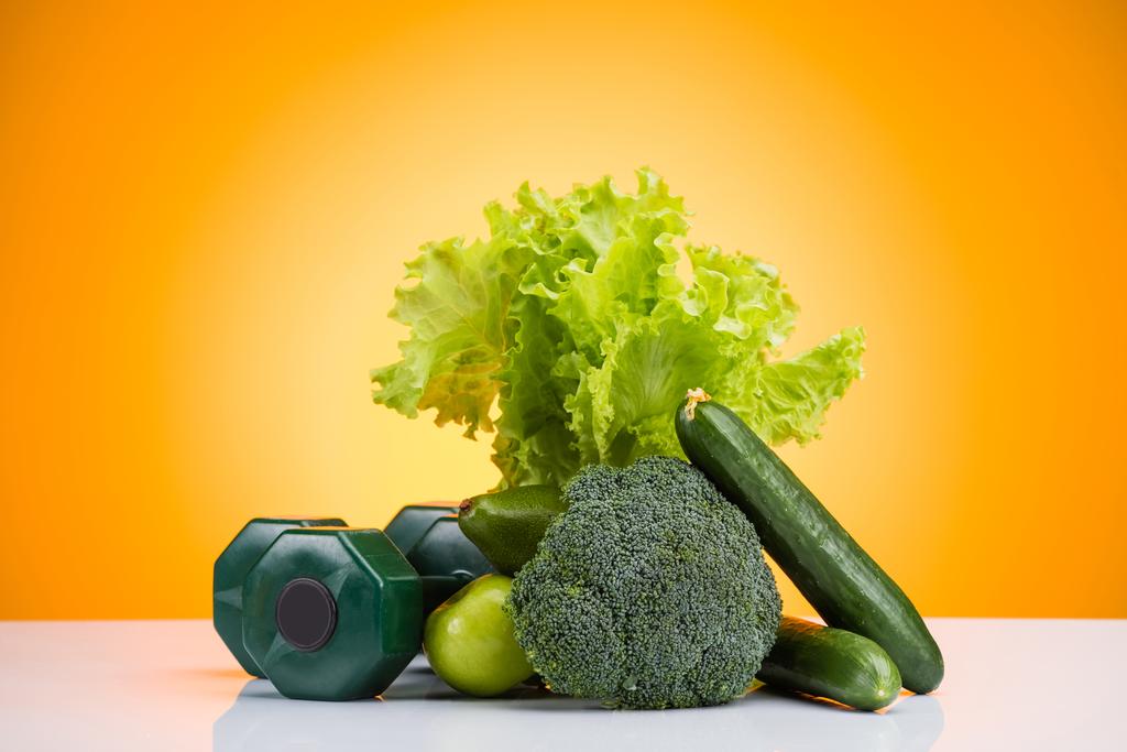 γκρο πλαν θέα πράσινο αλτήρες και φρέσκα φρούτα και λαχανικά στο κίτρινο - Φωτογραφία, εικόνα