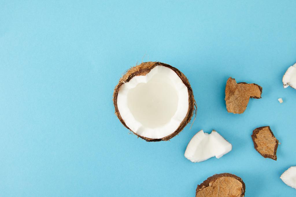bovenaanzicht van gearrangeerde kokosnoot stukken geïsoleerd op blauw - Foto, afbeelding