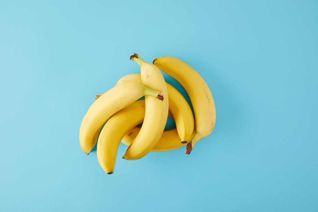 το Top view τοποθετημένα νωπών μπανανών που απομονώνονται σε μπλε - Φωτογραφία, εικόνα