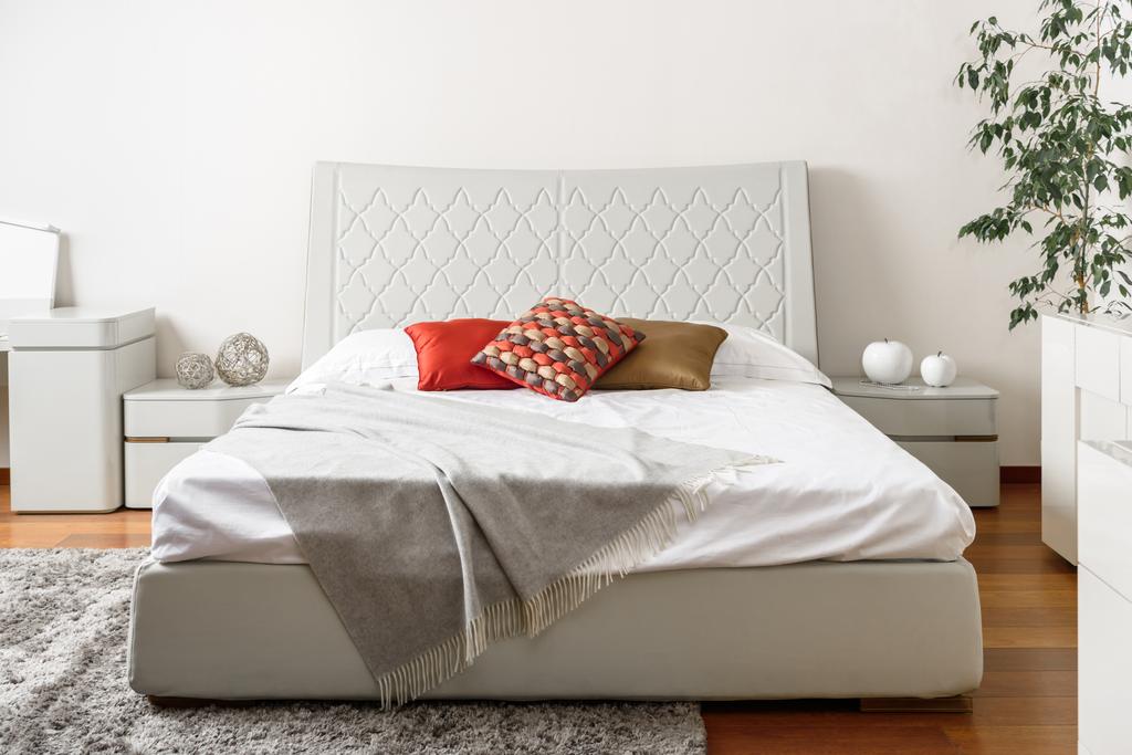 interior do quarto de luz moderna com travesseiros coloridos na cama branca
 - Foto, Imagem