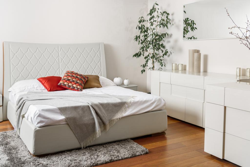 интерьер современной светлой спальни с цветными подушками на кровати
 - Фото, изображение