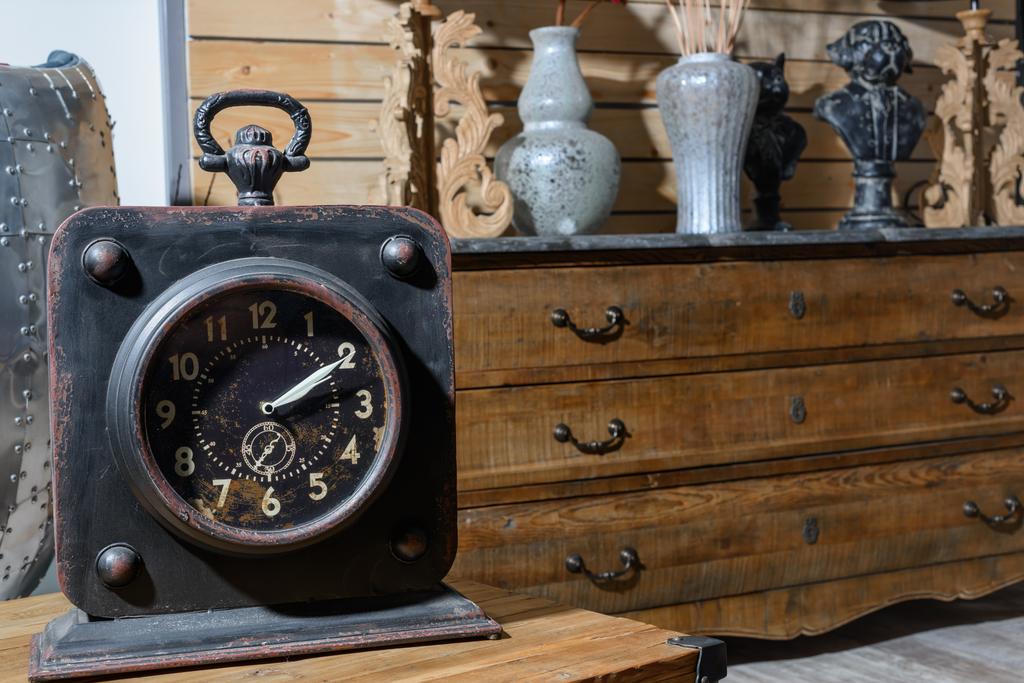 старий старовинний годинник на дерев'яному столі в сучасній ретро-стилі вітальні
 - Фото, зображення