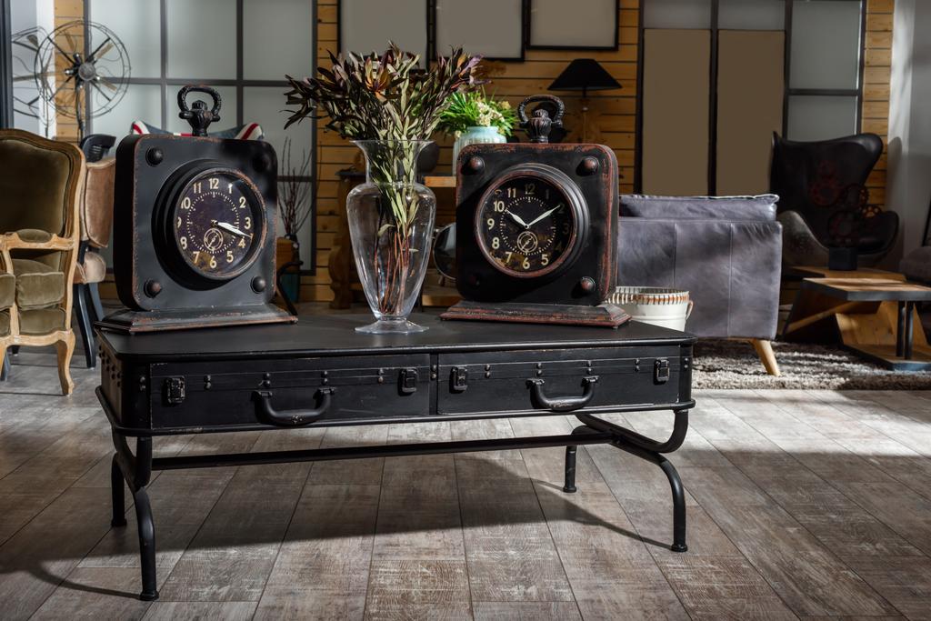 interno di moderno soggiorno in stile retrò con due orologi e fiori secchi su tavolo nero in legno
 - Foto, immagini