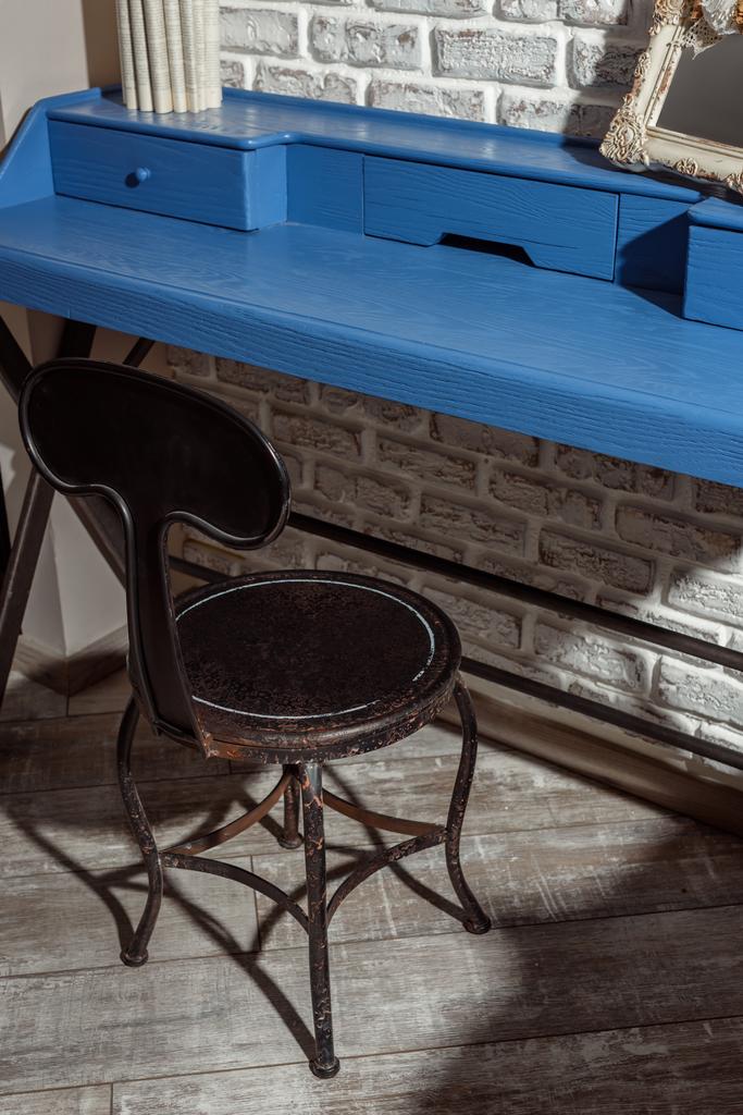 houten stoel aan blauwe tafel in moderne retro ingerichte woonkamer - Foto, afbeelding