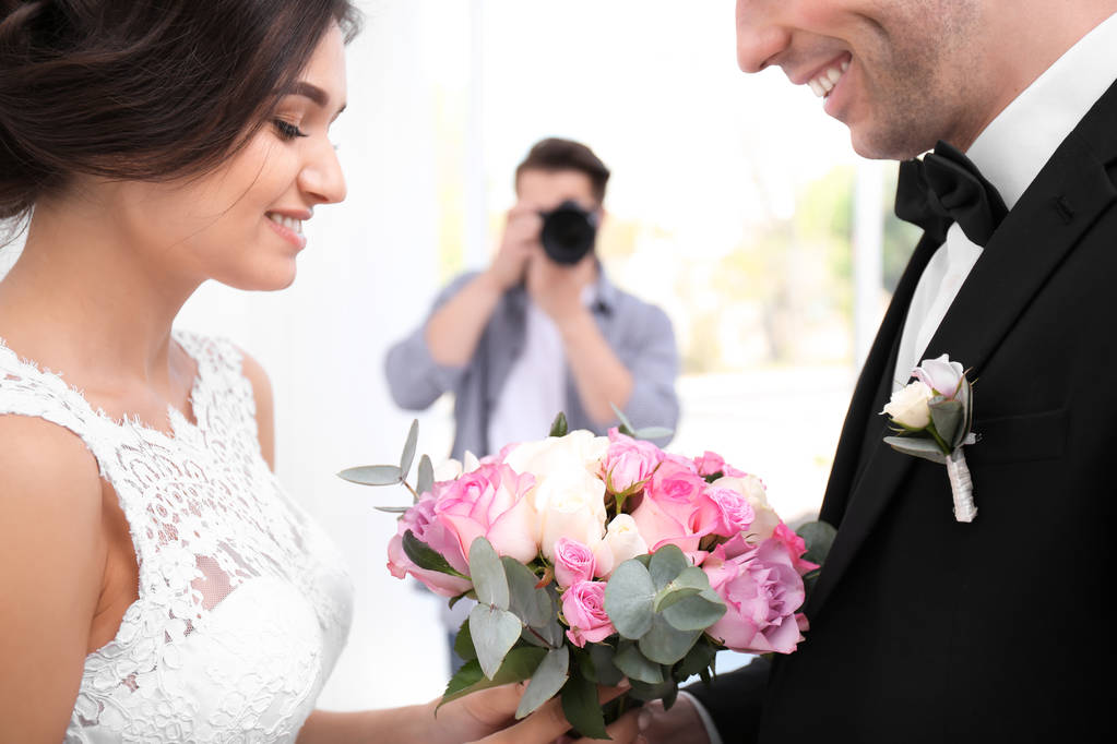 Fotógrafo profesional tomando fotos de pareja de boda en estudio
 - Foto, imagen