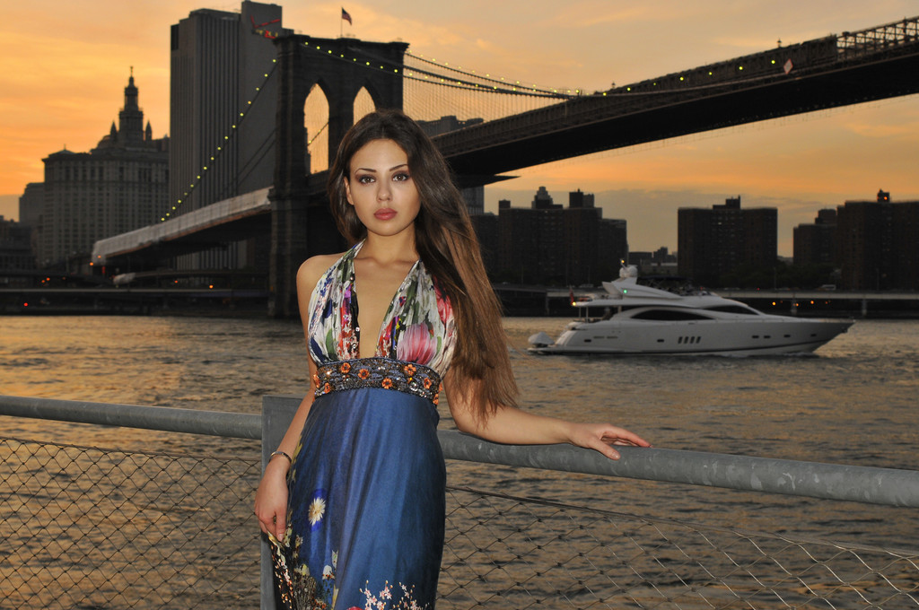 Modelo de moda posando em vestido azul longo na frente da Brooklyn Bridge em Nova York
 - Foto, Imagem