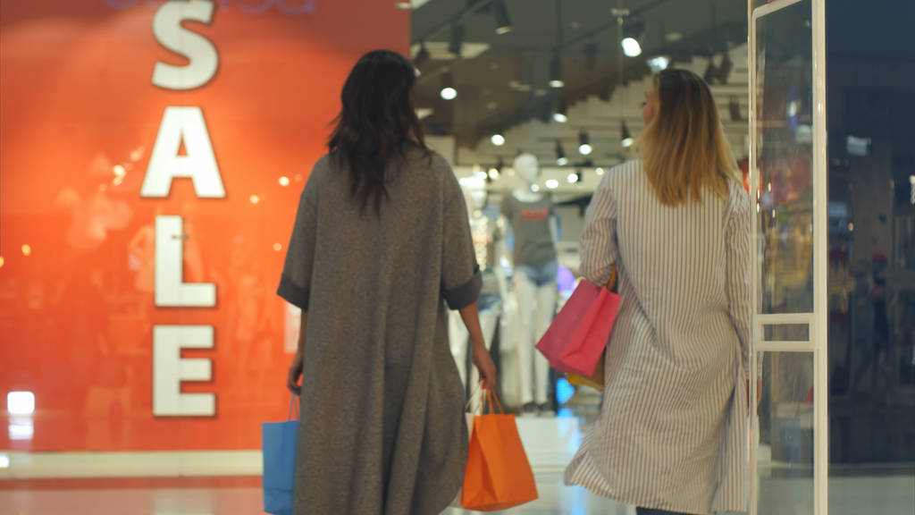 Due giovani donne notano il cartello di vendita nel negozio
 - Foto, immagini
