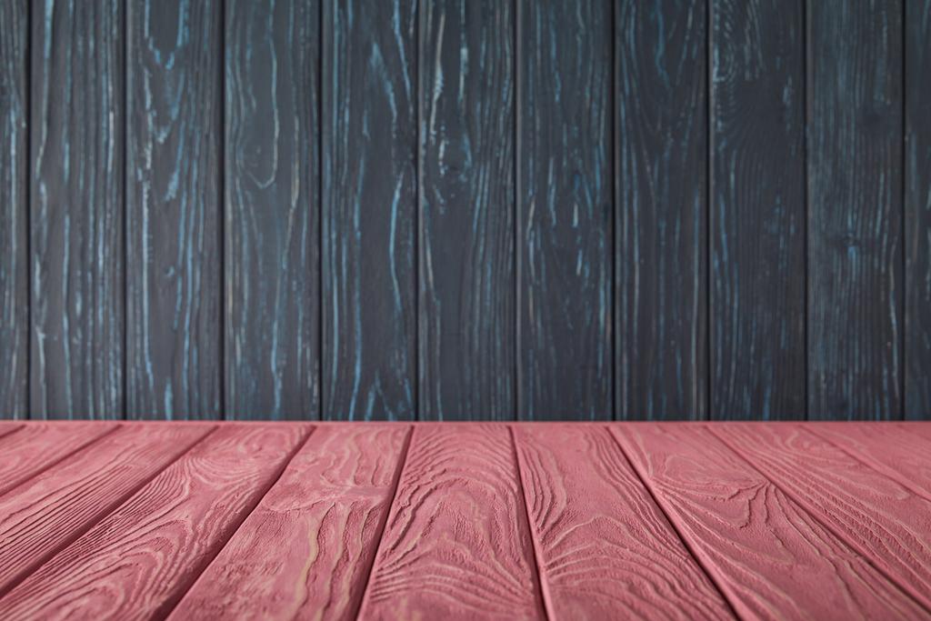 Roze gestreepte tafelblad en donker blauwe houten muur - Foto, afbeelding