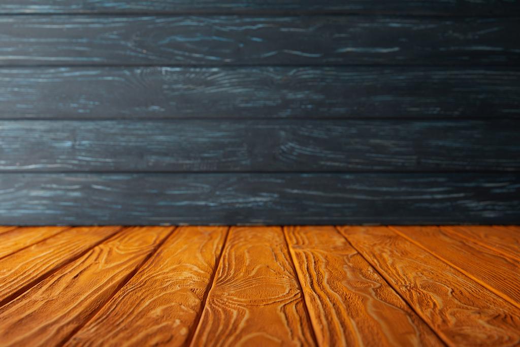 Oranje gestreepte vloer en donker blauwe houten muur - Foto, afbeelding