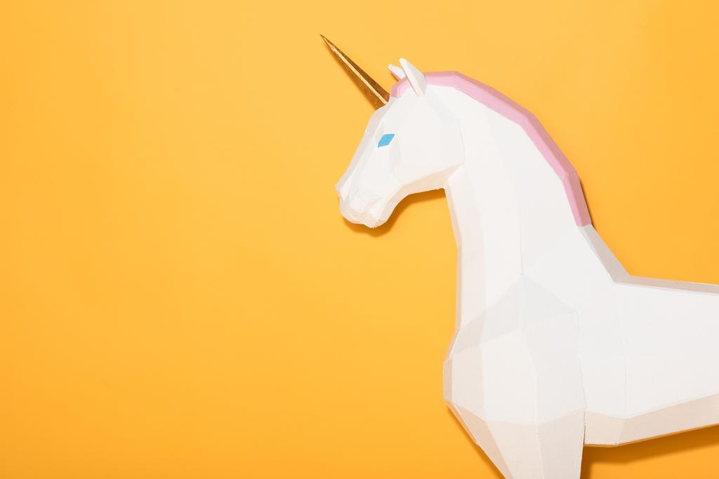 side view of decorative unicorn standing on yellow background  - Photo, Image
