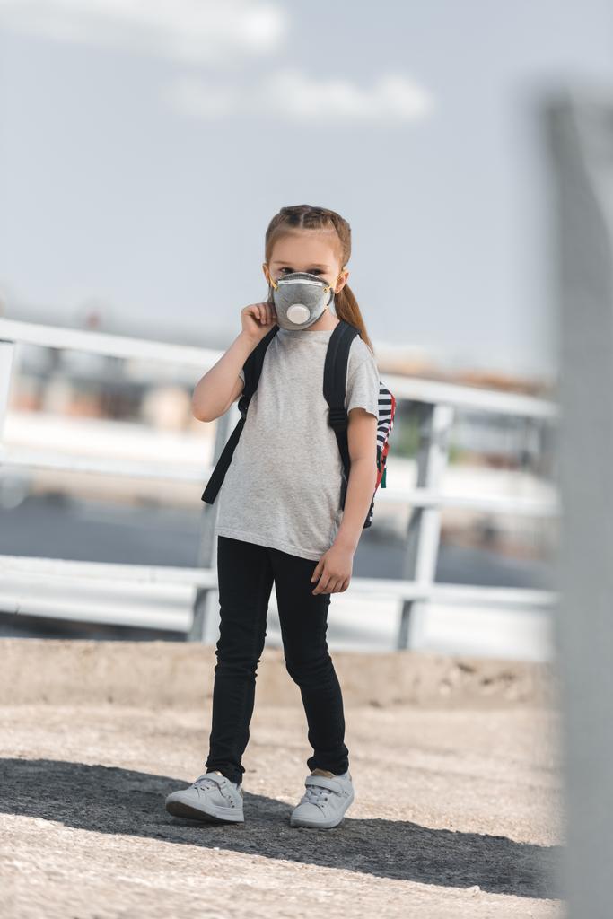 child in protective mask walking to school on bridge, air pollution concept - Photo, Image