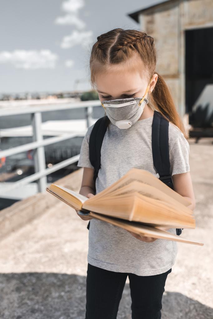 criança em máscara protetora livro de leitura sobre ponte, conceito de poluição do ar
 - Foto, Imagem