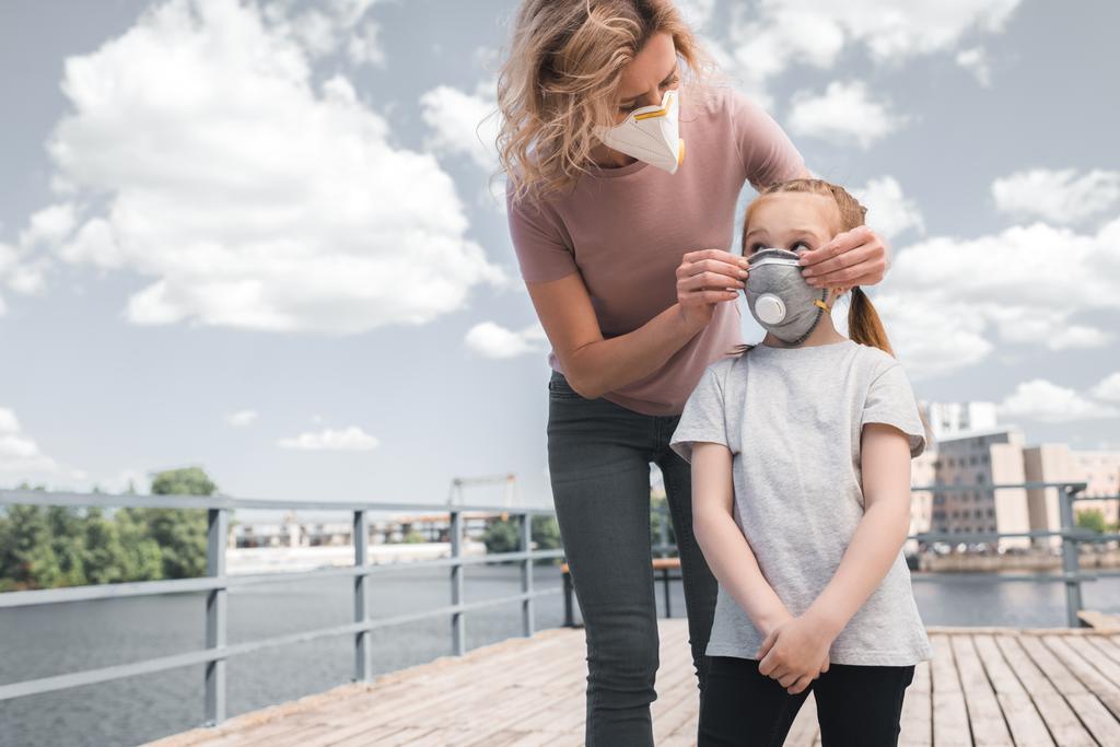 防護マスク、空気汚染概念の橋の上で母と娘 - 写真・画像