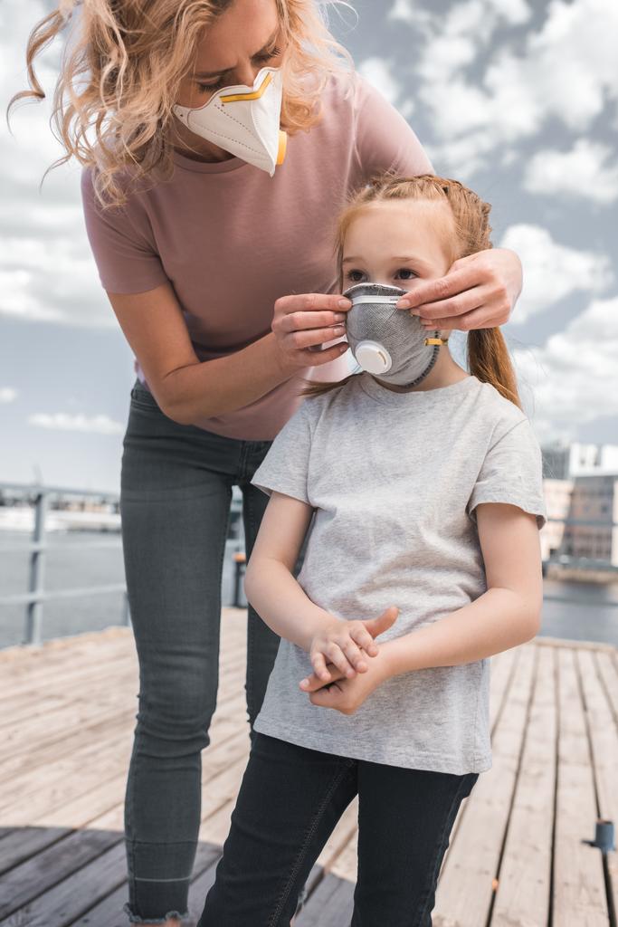 matka, noszenie maski ochronne na córkę do oddychania, pojęcie zanieczyszczenia powietrza - Zdjęcie, obraz