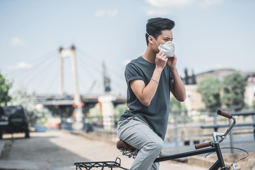 asiático adolescente usando máscara protetora com bicicleta, conceito de poluição do ar
 - Foto, Imagem