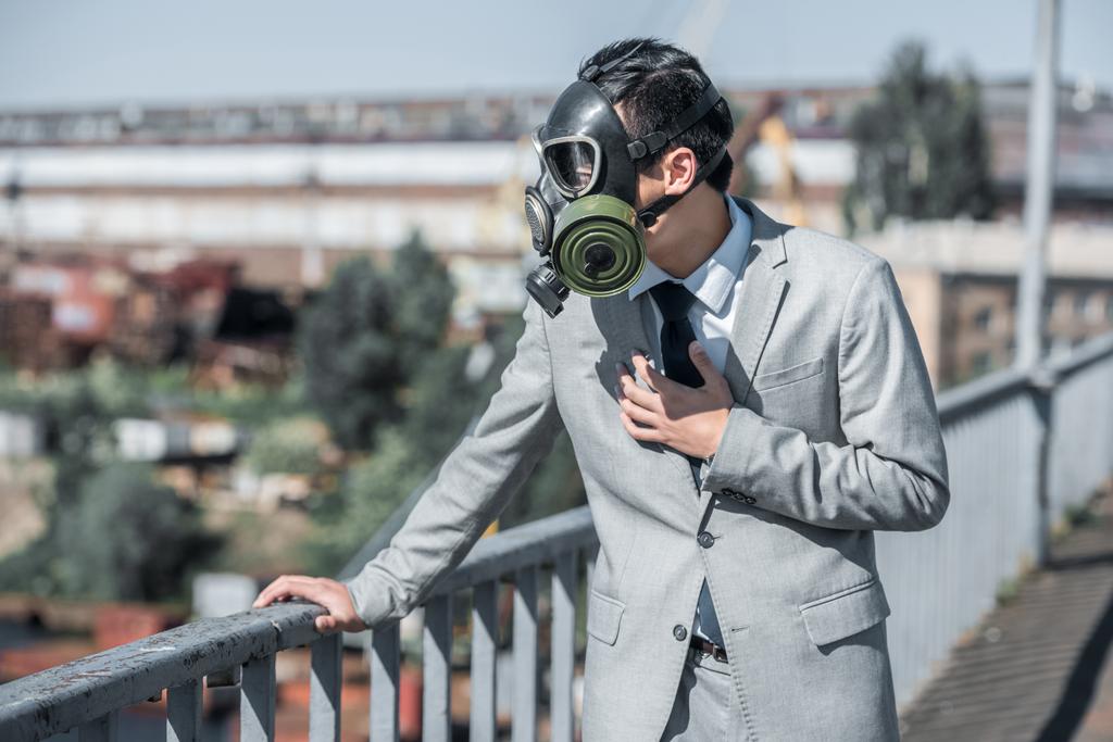businessman in gas mask having problem with breathing on bridge, air pollution concept - Photo, Image
