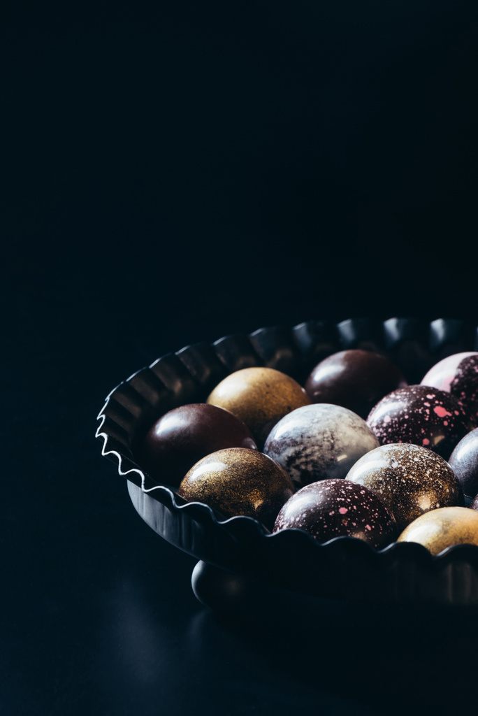 Detailní pohled hromadu různých čokoládové bonbony v misce na černém pozadí  - Fotografie, Obrázek