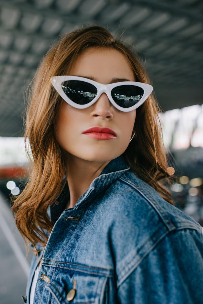 портрет молодой модной женщины в джинсовой одежде и ретро солнцезащитных очках
 - Фото, изображение