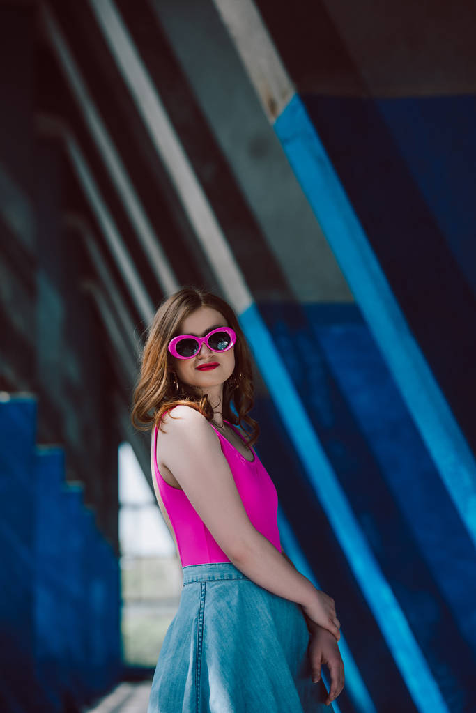 retrato de mulher sorridente elegante em óculos de sol retro rosa e saia jeans
 - Foto, Imagem