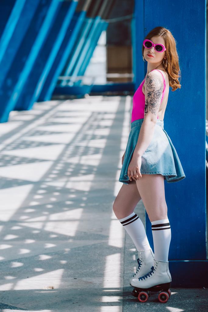 サングラス、デニムのスカートとローラー スケートの通りに立っている間カメラ目線で魅力的な女の子 - 写真・画像