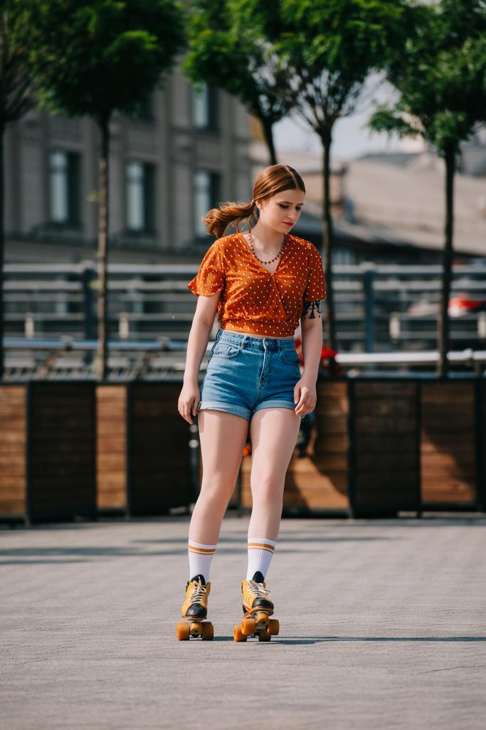 bella ragazza elegante in pantaloncini di jeans pattinaggio a rotelle sulla strada
 - Foto, immagini