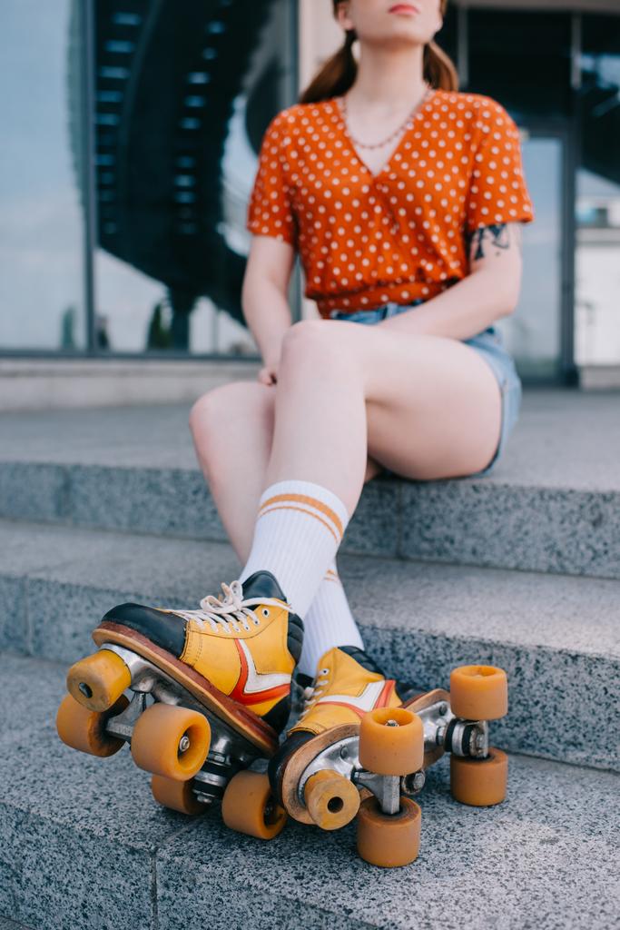 cropped shot of girl in roller skates sitting on stairs - Photo, Image