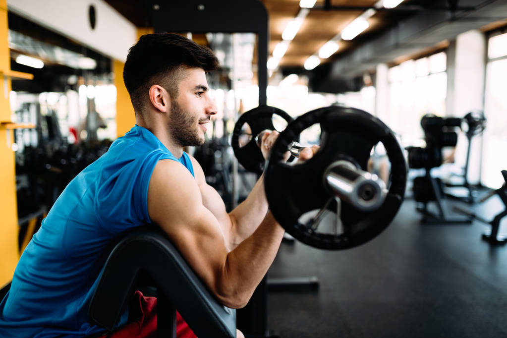 Exercício masculino determinado no ginásio mantendo o corpo em forma
 - Foto, Imagem