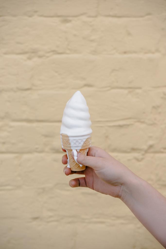 primo piano vista parziale della ragazza che tiene delizioso gelato in cono cialda
 - Foto, immagini