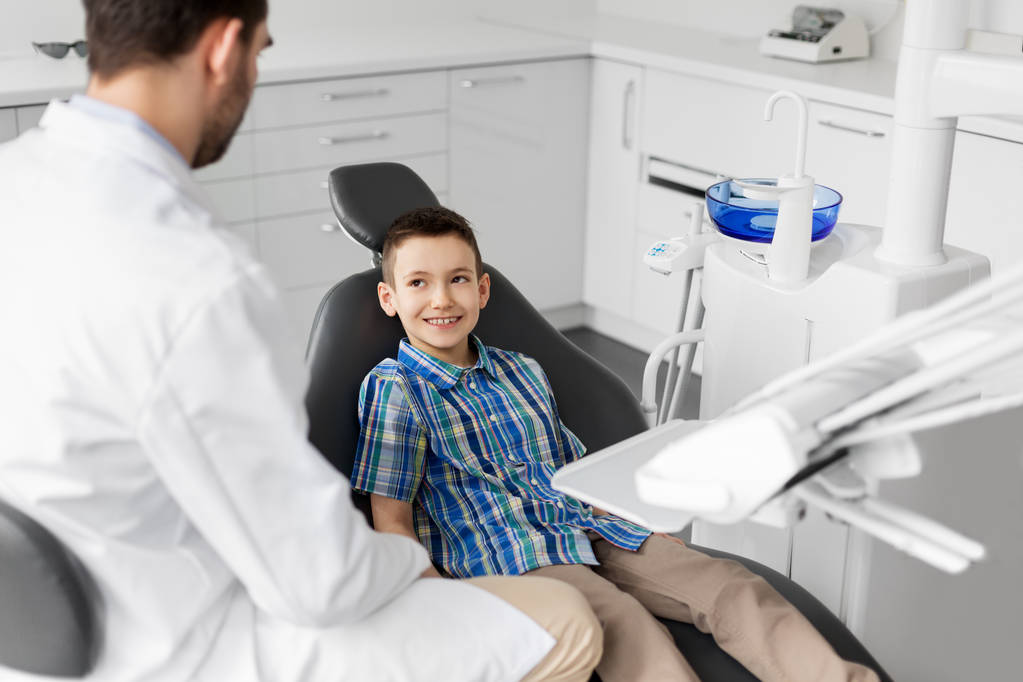 dentista falando com paciente criança na clínica odontológica
 - Foto, Imagem