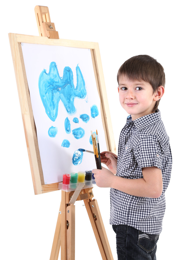 kleine jongen schilderij schetst beeld op ezel geïsoleerd op wit - Foto, afbeelding