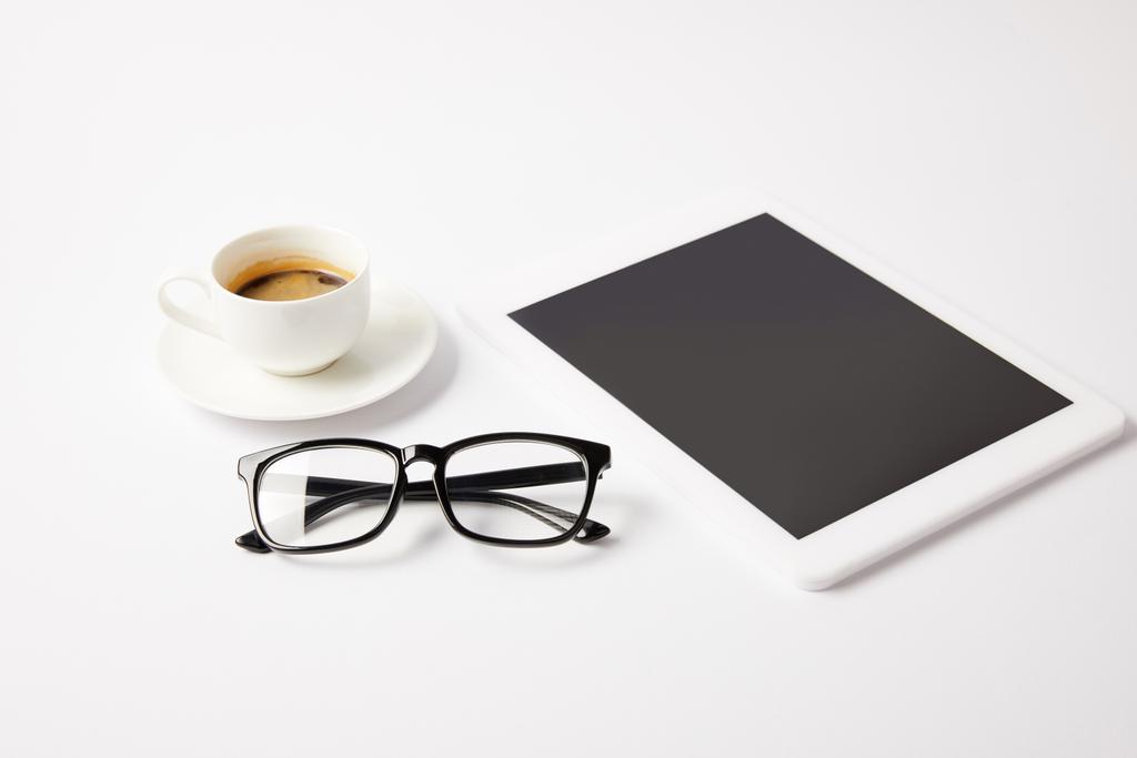 Чашка кофе, стаканы и цифровой планшет с чистым экраном на белом столе
 - Фото, изображение