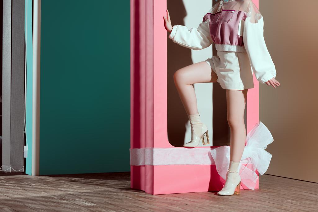 Oříznout záběr módní dívka pózuje v Dekorativní růžový box s lukem - Fotografie, Obrázek