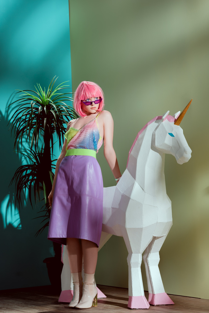 bella ragazza alla moda in parrucca rosa appoggiata all'unicorno
 - Foto, immagini