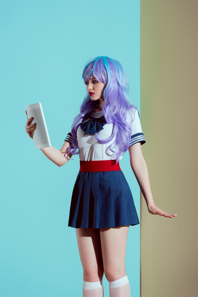 молодая женщина в ярком парике с помощью цифрового планшета в студии
 - Фото, изображение